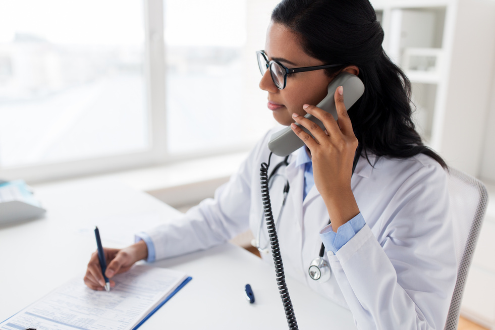 Doctor with Clipboard Calling on Phone 